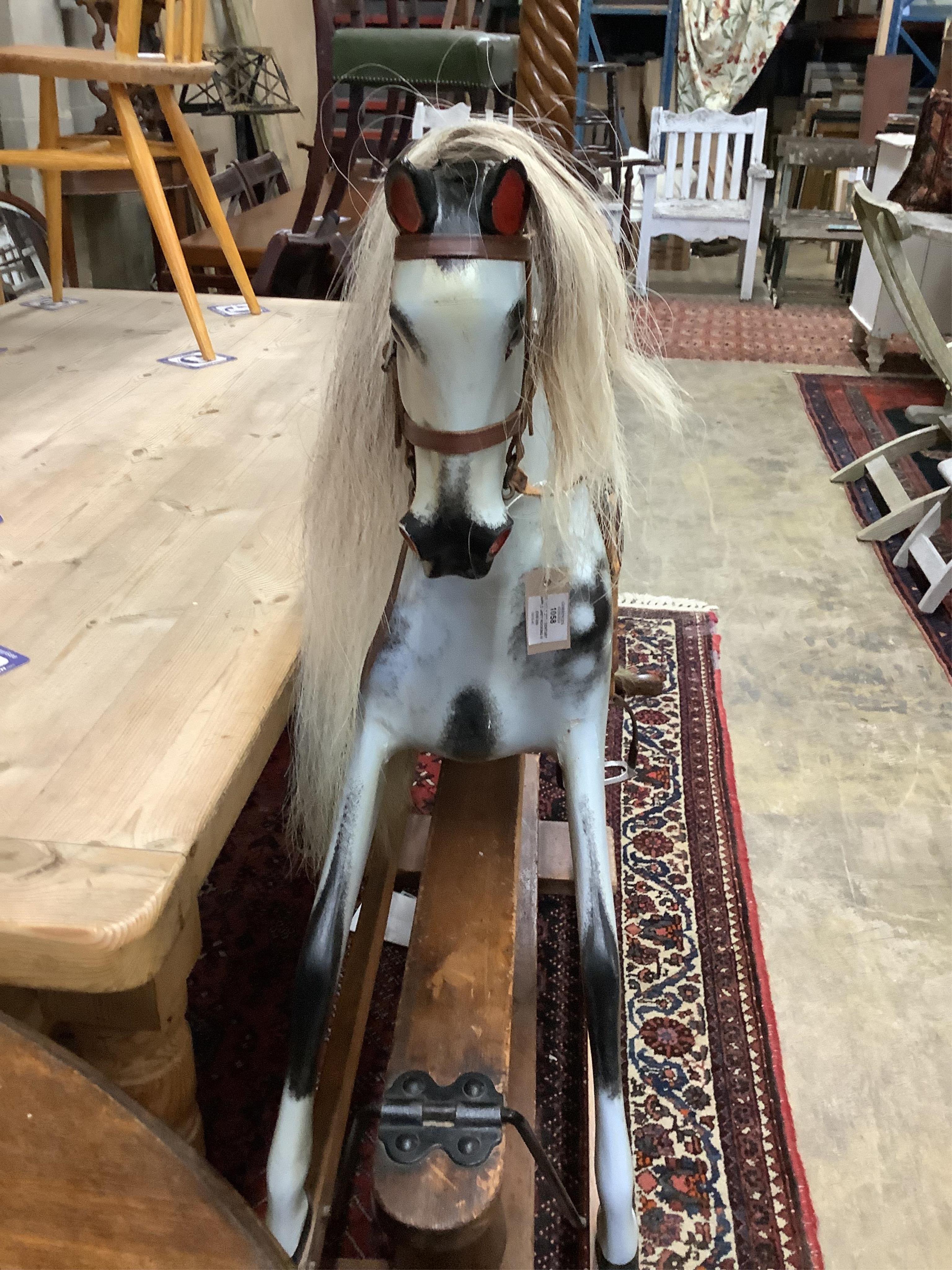 An early 20th century dapple grey rocking horse on pine safety frame, width 126cm, height 116cm. Condition - fair-good